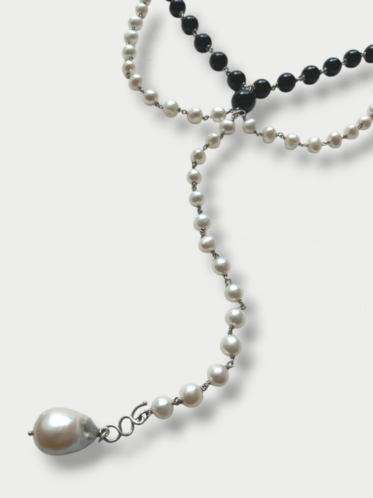 Detail of a black and white composition necklace with pearls and onyx beads, silver (925) detailing, displayed against a white background.