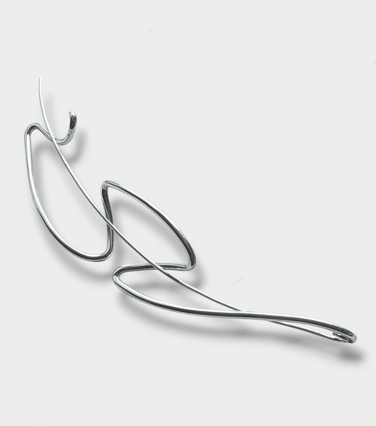 Experimental silver (925) brooche, simple fluid design against a white background