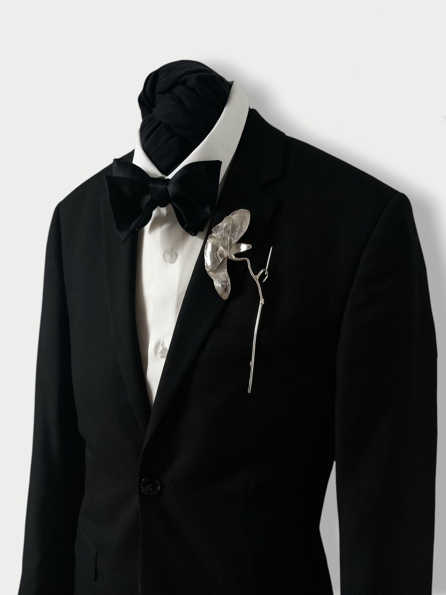 Solid silver (925) flower brooch pinned to the lapel of a black tuxedo suit jacket