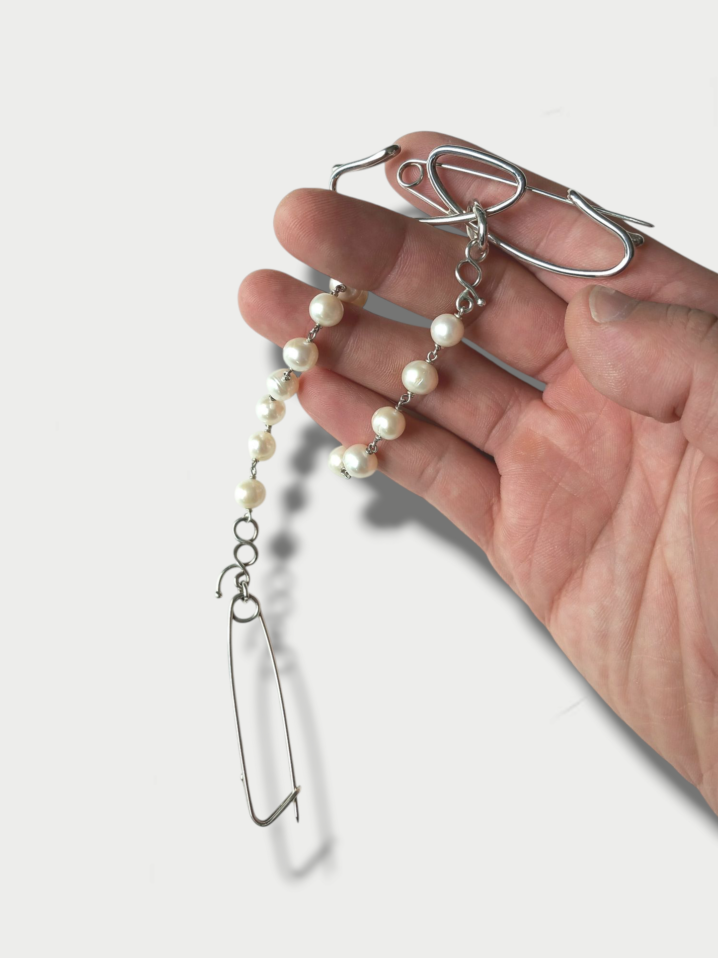 deco' inspired silver (925) and pearls pin held in hand to show size and scale