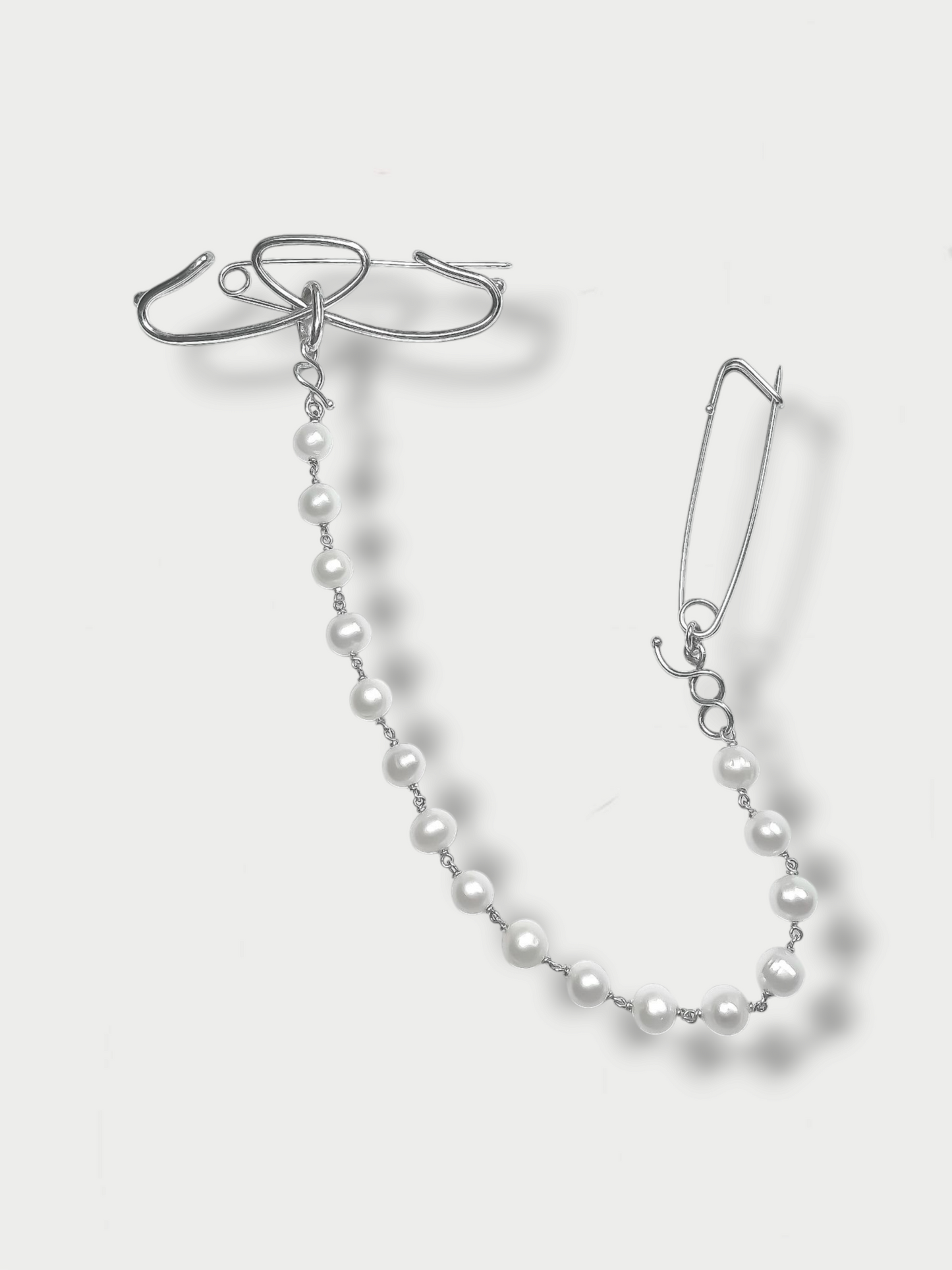 statement art deco' inspired silver(925) pin with pearls against light background