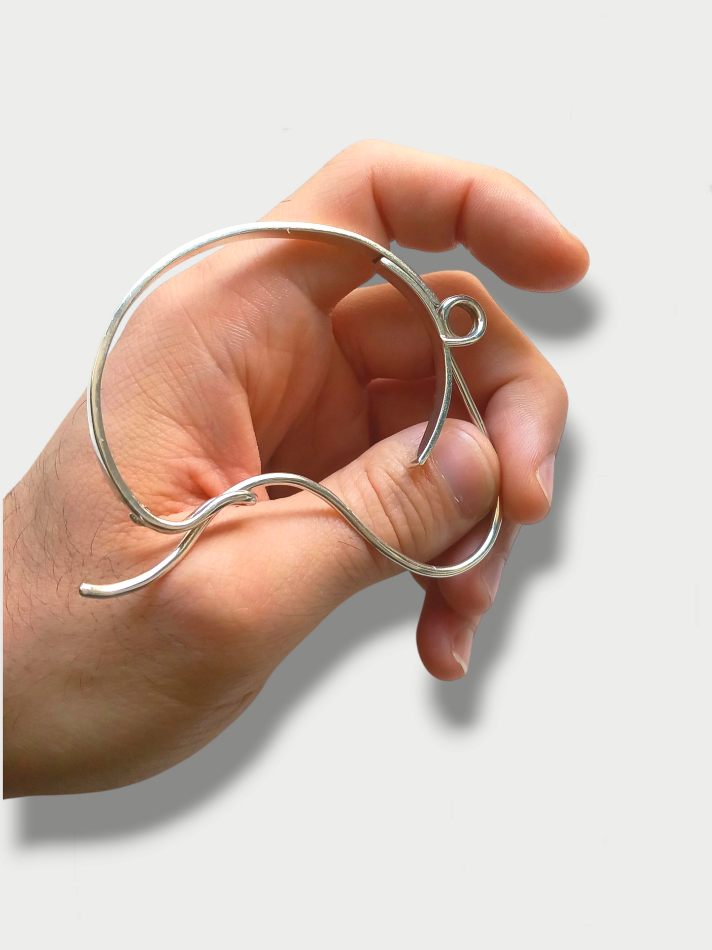 Anthony Was Here experimental safety pin inspired sterling silver bracelet being held by hand showing loop detail and shape